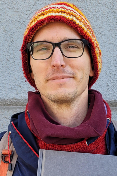 prelegent mężczyzna w średnim wieku w kolorowej czapce i okularach