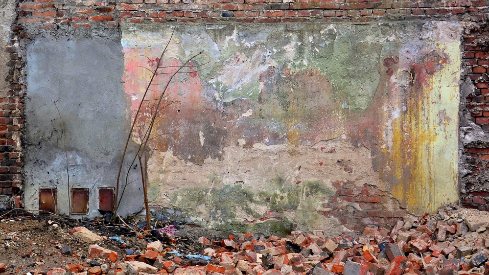 a photo of a multi-coloured wall with bricks lying in front of it