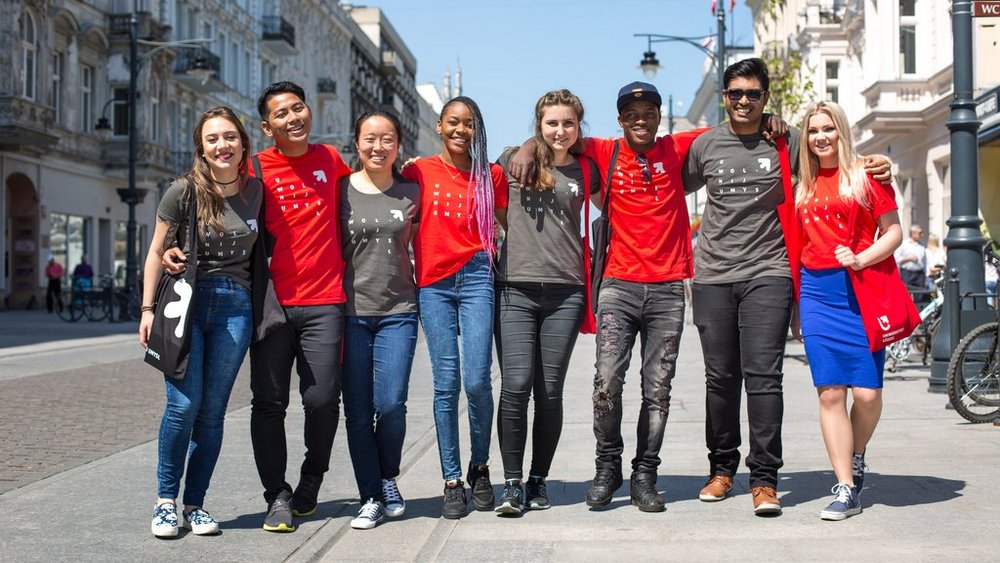 A group of young people of different races standing together on Piotrkowska Street in Lodz