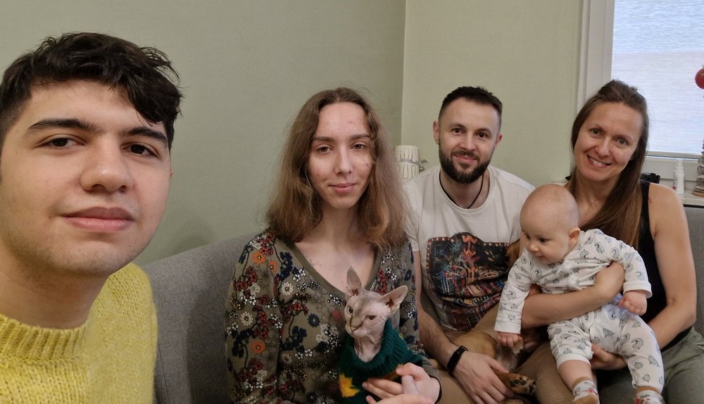 Uczestnicy akcji UŁ Gość na Gwiazdkę, dwóch mężczyzn i dwie kobiety uśmiechający się do dziecka, kobieta trzyma niemowlę