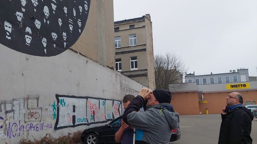 osoba niedowidząca oglądająca mural za pomocą telefonu